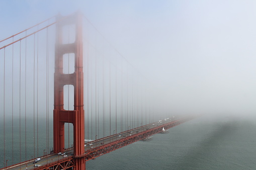 Early morning fog blankets the Golden Gate, sunrise red the sky.