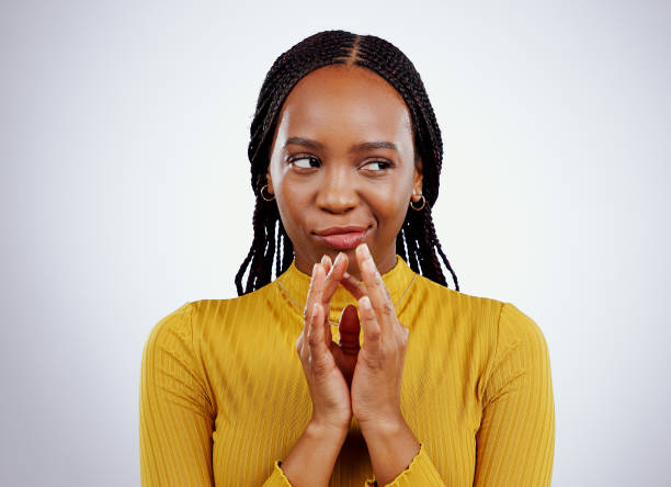 istock Thinking, smirk and black woman with scheme hands in studio for evil, planning or revenge on grey background. Plotting, villain and African female model with steeple emoji for brainstorming idea 1849679550