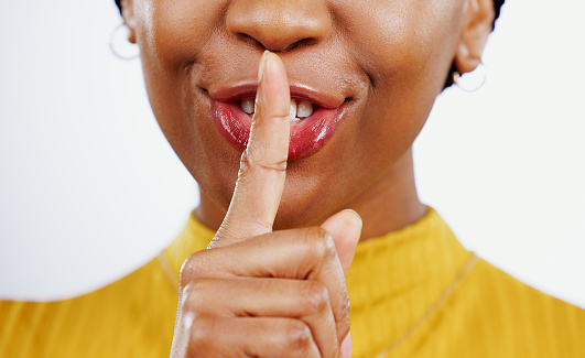 Secret, woman and hands with finger on lips in studio for privacy, confidential deal and surprise on white background. Closeup, mouth and face of model with quiet emoji for gossip, news and whisper