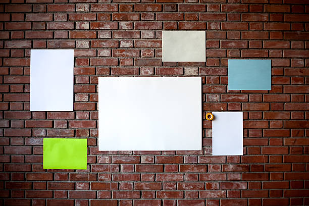 differently colored of blank papers on the wall stock photo