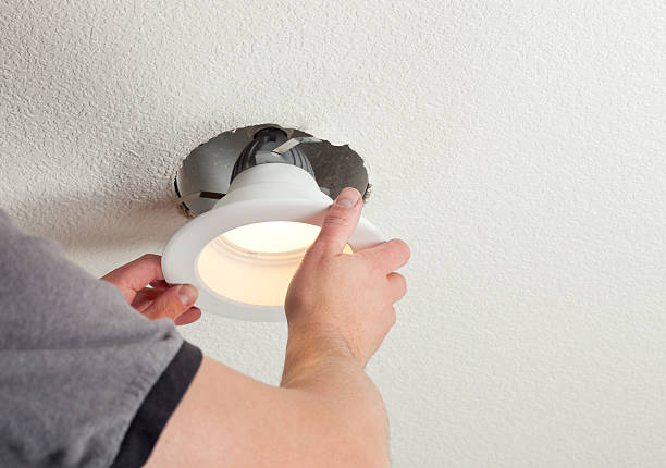 Installing LED Retrofit Bulb into Ceiling Fixture  household fixture photos stock pictures, royalty-free photos & images