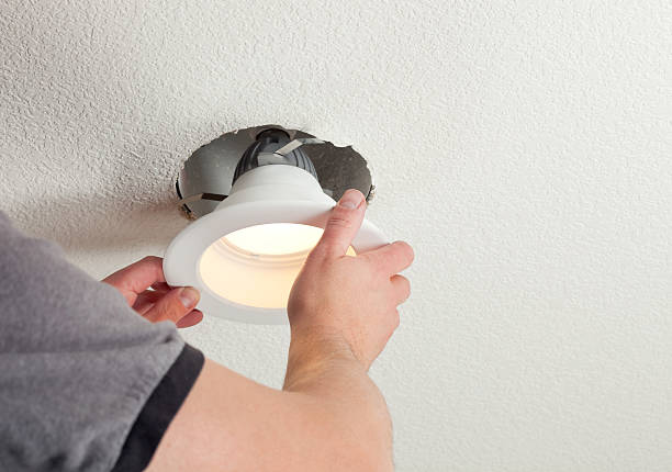 Installing LED Retrofit Bulb into Ceiling Fixture  recessed light stock pictures, royalty-free photos & images