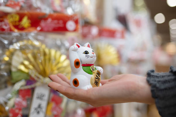Woman's hand choosing a beckoning cat