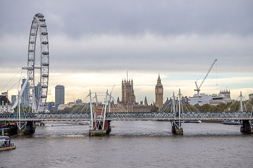Waterloo Bridge, London, England - October 27th 2023: View up the river Thames toward the London Eye, the parliament and Big Ben with the Golden Jubilee Bridges in the front