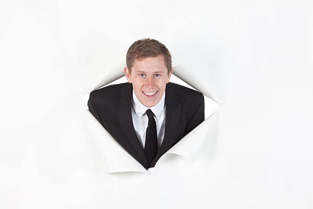istock Businessman emerging from a hole of paper 184969055