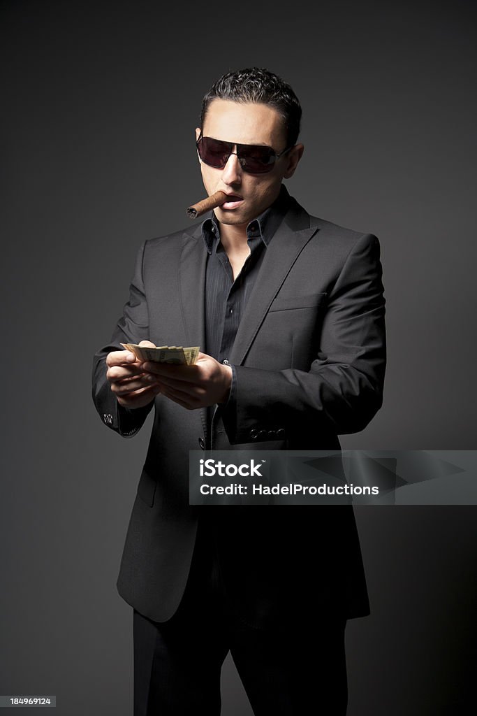 Empresário em terno preto com um charuto e dinheiro - Foto de stock de Adulto royalty-free