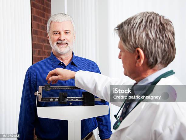 Arzt Mit Einem Gewicht Von Patienten Stockfoto und mehr Bilder von Allgemeinarztpraxis - Allgemeinarztpraxis, Arzt, Dick