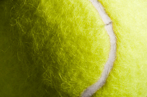 Cropped section of a fluffy yellow tennis ball