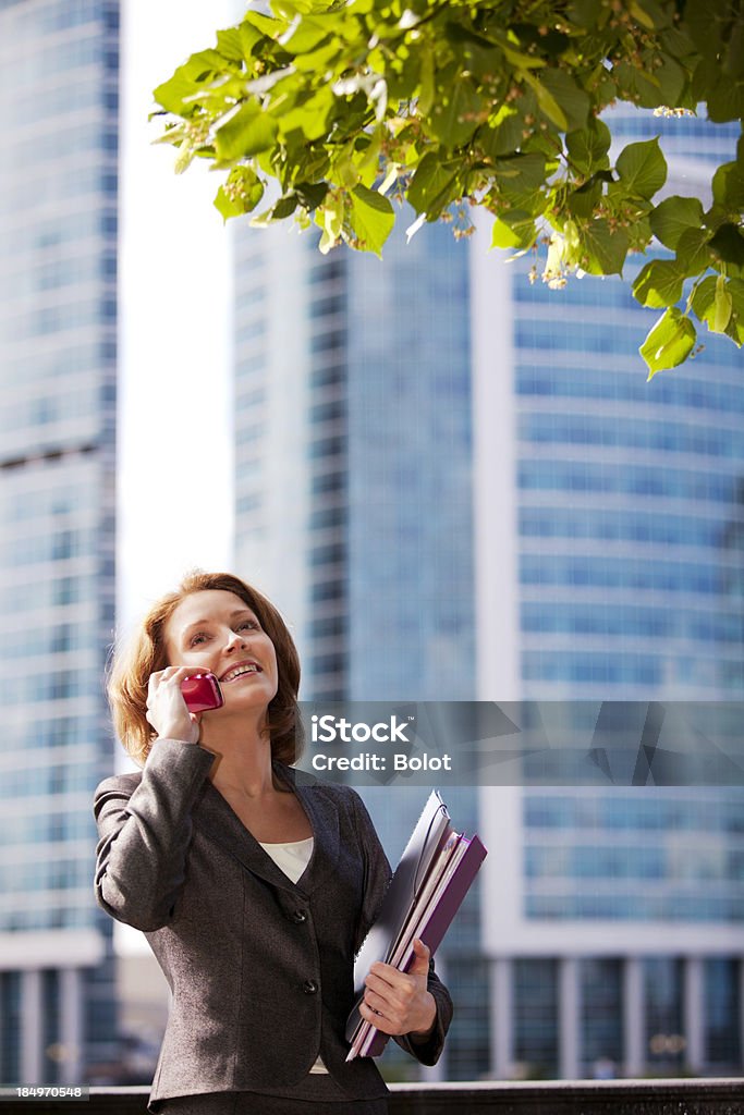 Smiling businesswoman talking on mobile phone outdoors 30-39 Years Stock Photo