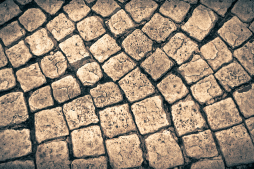 Old exterior cobblestone floor called Sanpietrini in Italy.