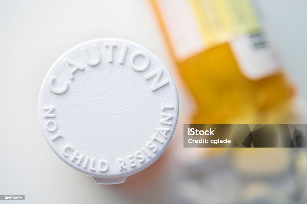 Keep Away from Children Prescription drugs container that is not childproof with one open in the background Accessibility Stock Photo