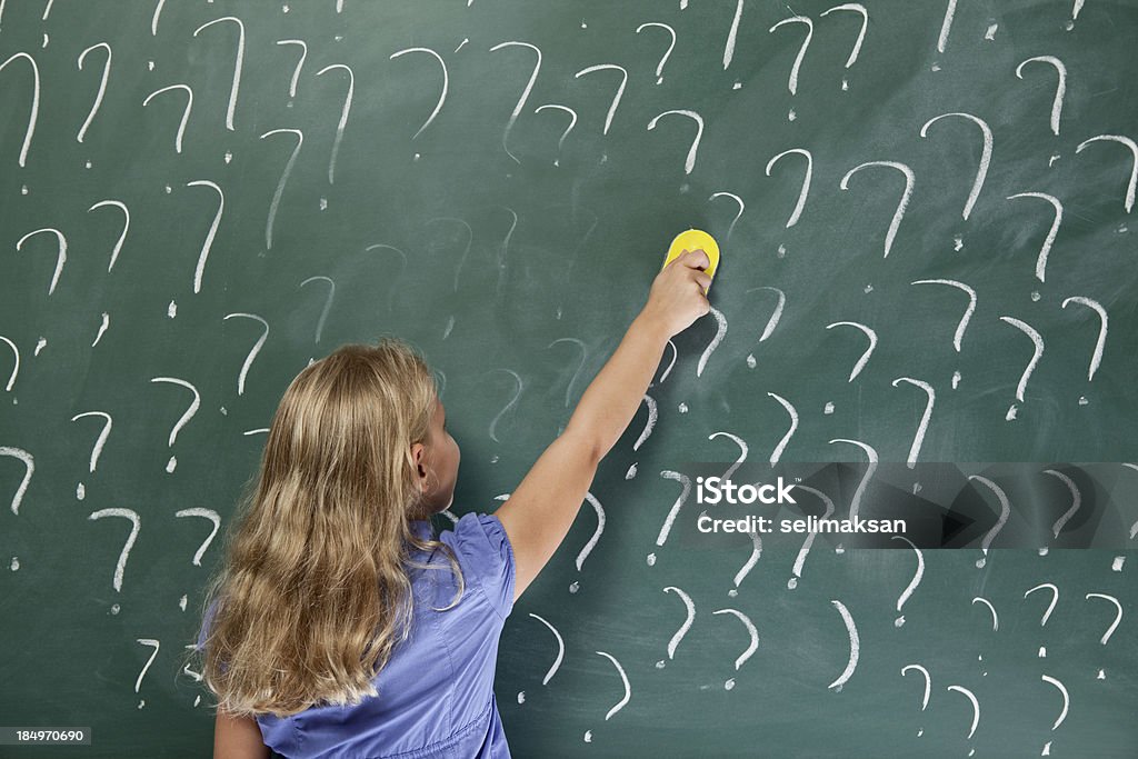 Little school girl eliminación pregunta es en pizarra - Foto de stock de Borrador para pizarra libre de derechos