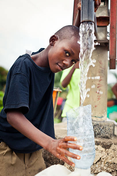 istock African-American boy getting water from a water pump 184970705