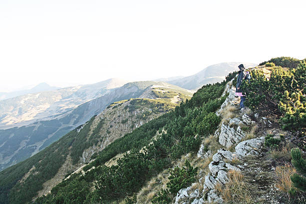 istock Women stending on the edge of mountan peak 184971606