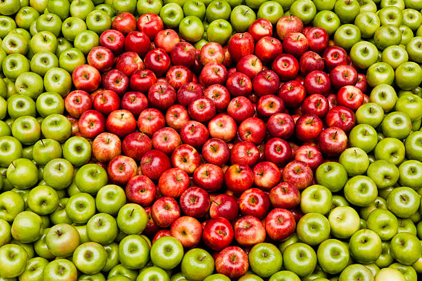 Organic fresh farm honey crisp apples photographed from above in a heart shaped bowl.