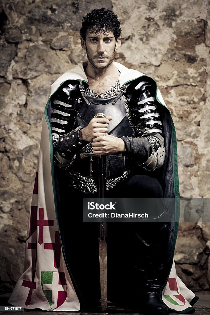 kneeling knight "mystical portrait of  a medieval kneeling Knight with sword and tunic,selective focus, very creative color retouching to underline the ancient medieval time,vignetting and possible noise see more:" Sword Stock Photo