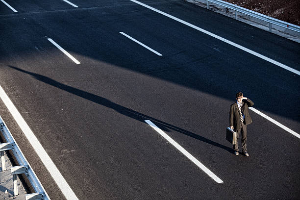 istock Businessman standing and looking forward in the middle of highwa 184972003