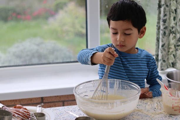 Child mixing cake batter for making waffle cake at home