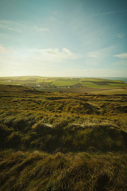 istock Grassy fields and distant town in northern France 184972179