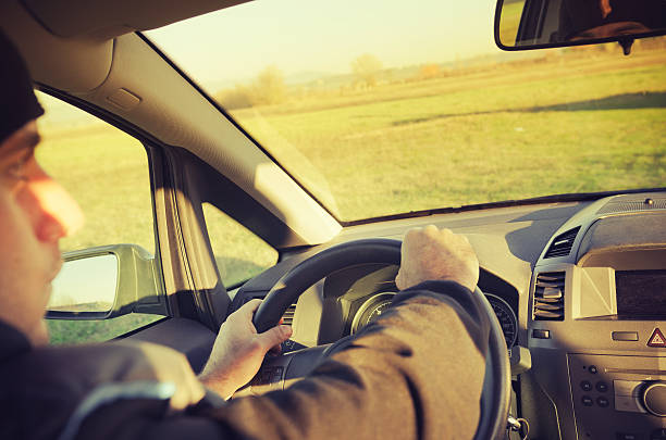 jeune homme au volant de sa voiture avec tableau de bord - side view mirror audio photos et images de collection
