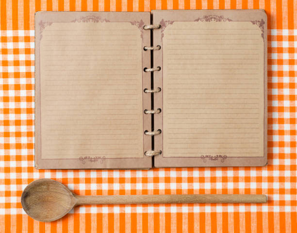 istock Antique notebook and wooden spoon on orange tablecloth 184972993