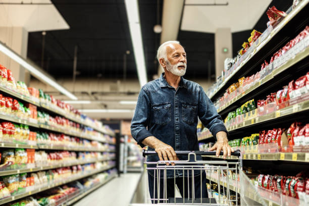 istock Man Reaching Up To Top Shelf To Take Item While Grocery Shopping. 1849729933