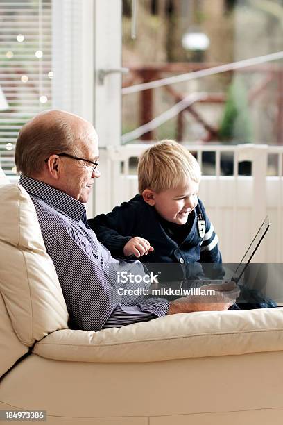 Photo libre de droit de Grandpère Et Son Petitfils Ensemble Sur Ordinateur Portable banque d'images et plus d'images libres de droit de 4-5 ans