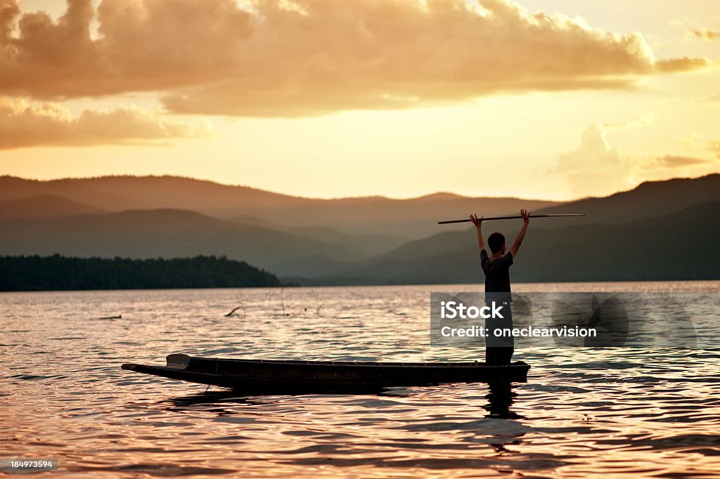 Hombre de pie en una canoa - Foto de stock de Actividades recreativas libre de derechos