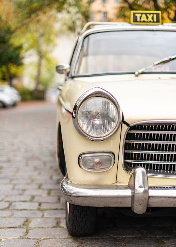 Baden-Baden, Germany - 14 July 2019: beige ivory Fiat 1100 small family sedan 1953 1969 is parked in Kurpark in Baden-Baden at the exhibition of old cars \