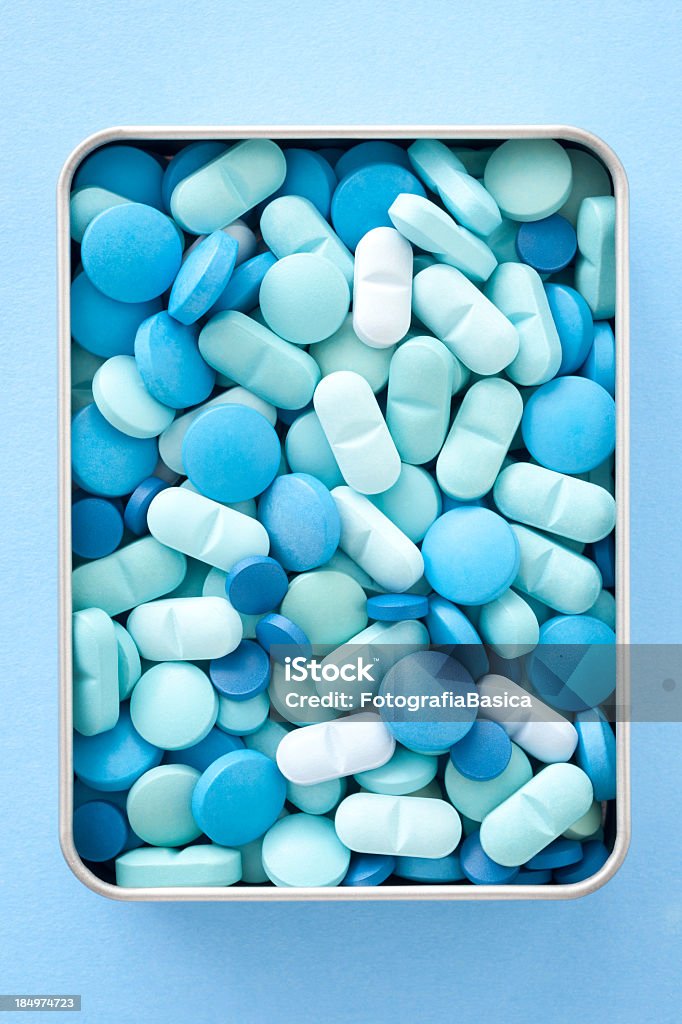 Blue pills in box Closeup view of many blue pills inside tin can Abundance Stock Photo