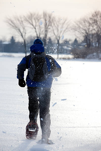 running homme avec raquettes en hiver neigeux jour - winter snowshoeing running snowshoe photos et images de collection