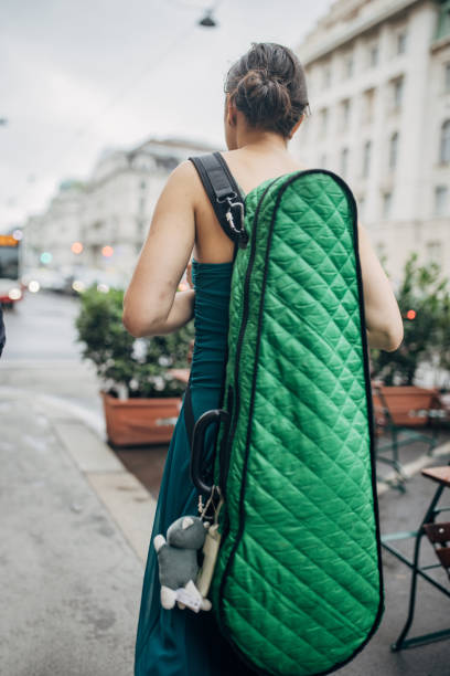 Young woman musician with violin case walking the streets in Vienna.