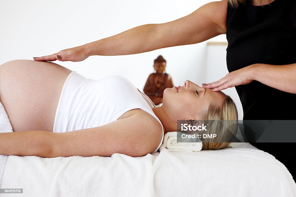 massage thérapeutique sur femme enceinte au centre de bien-être - Photo de Masser libre de droits