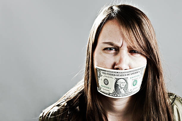 jeune femme fronce les sourcils de nous un dollar bill bâillon - currency silence censorship behavior photos et images de collection