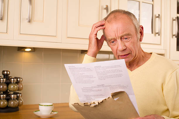 senior financial worry senior male stresses over bill divorcee stock pictures, royalty-free photos & images