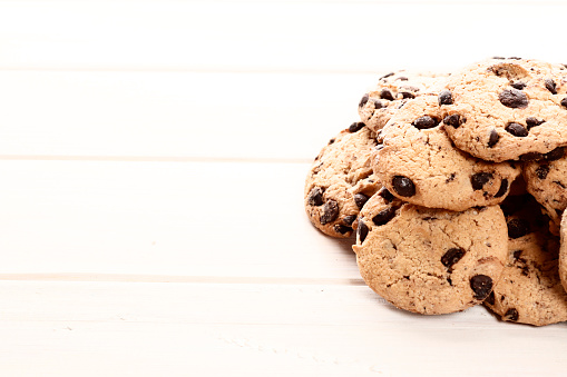 Delicious chocolate chip cookies on a white wooden background. Place for text. Top view.