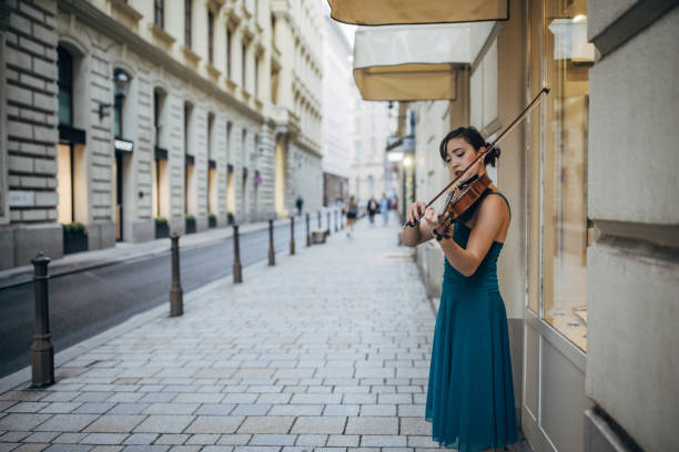Young woman violinist playing the violin on the street in Vienna.