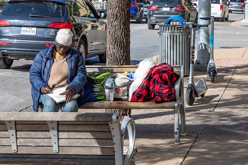 Austin, Texas - November 3, 2023: homeless people sleep at a bench downtown Austin, Texas.