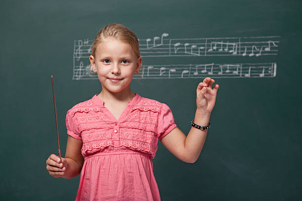 bambina dirigere chorus per musica folk prima di lavagna - ballad foto e immagini stock