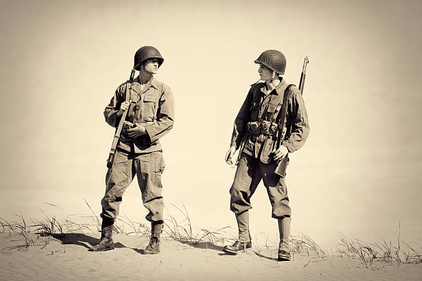 Two Vintage WWII Soldiers "Two Vintage WWII Soldiers.  Authentic clothing, boots, helmet, rifles, ammo belt etc.  1940's  Copy space available." military photos stock pictures, royalty-free photos & images