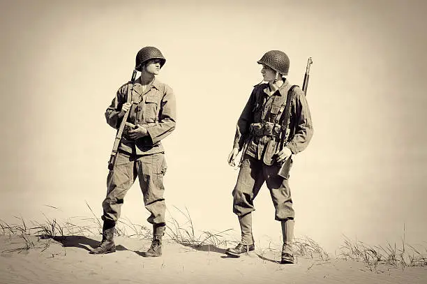 "Two Vintage WWII Soldiers.  Authentic clothing, boots, helmet, rifles, ammo belt etc.  1940's  Copy space available."