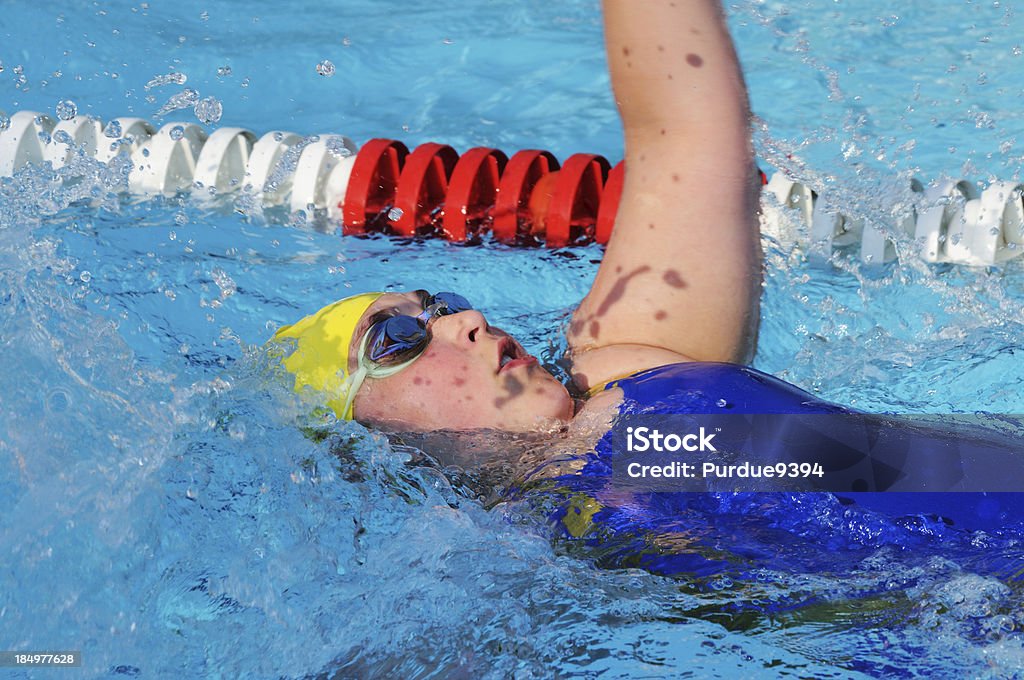Female Youth Child Backstroke Swimmer Racing in Swimming Pool Female youth backstroke swimmer racing in a swimming pool. Overweight Stock Photo
