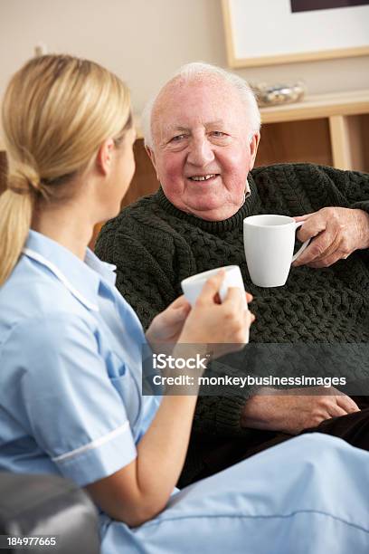 Foto de Enfermeira Visitando Homem Sênior Em Casa e mais fotos de stock de Terceira idade - Terceira idade, Caseiro, Profissional de enfermagem
