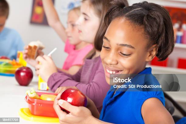 Linda Niña Comer Un Almuerzo En La Escuela Foto de stock y más banco de imágenes de Comedor - Edificio de hostelería - Comedor - Edificio de hostelería, Escuela primaria, Comer