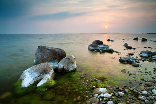 Tranquil Seascape with Huge Boulders on Rocky Coastline at Sunset