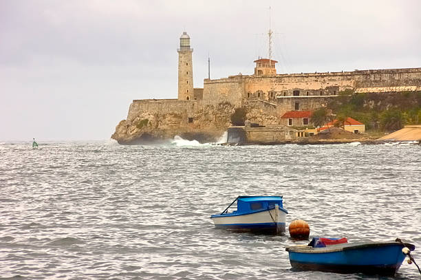 Havana Harbor Entrance And El Morro Castle Havana harbor entrance with a few small fishing boats and the El Morro Castle/Prison across the water. These are about the largest boats allowed on the northern side of Cuba havana harbor photos stock pictures, royalty-free photos & images