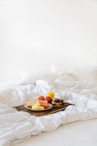 Breakfast tablett on a white messy bed.More like this: