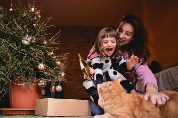 istock laughing family playing with cat while undressing Christmas tree. 1849791010