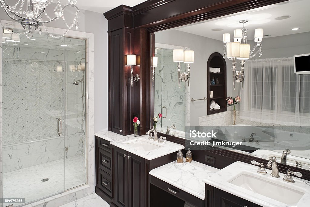 Luxurious marble master bathroom with hot tub tub. Luxurious custom light toned marble master bathroom with hot tub tub and walk-in shower with glass door. Bathroom Stock Photo