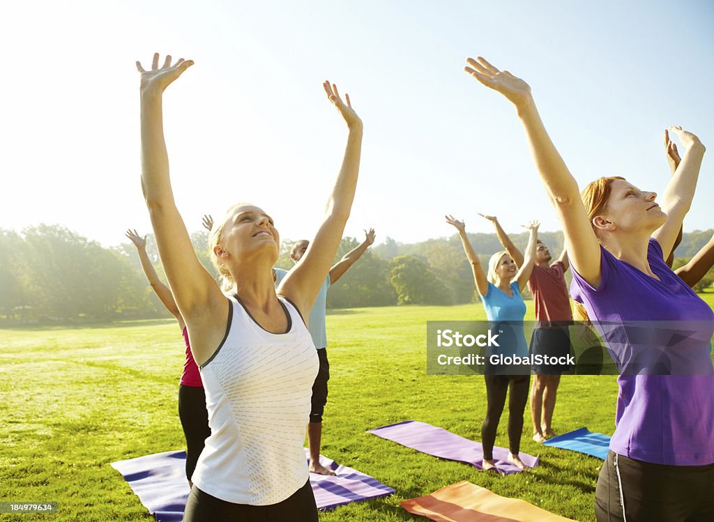Reaching for good health - Yoga Group of people reaching toward the skies as they do their yoga class outdoors 20-29 Years Stock Photo